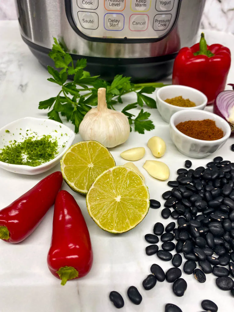 ingredients to make black bean soup in front of an instant pot