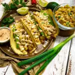 Mexican street corn chicken tacos plated with corn salsa and spicy crema