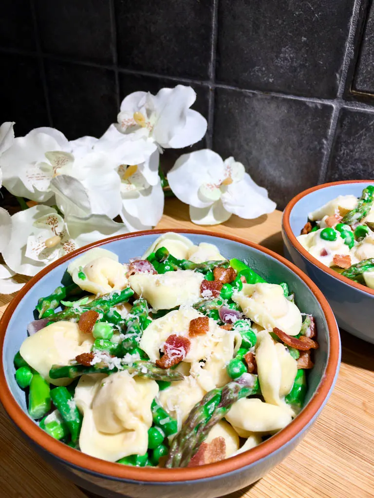 bowls of asparagus bacon and pea tortellini pasta