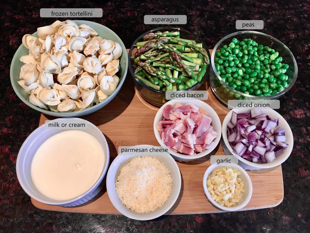 bowls with ingredients to make bowls of asparagus bacon and pea tortellini pasta