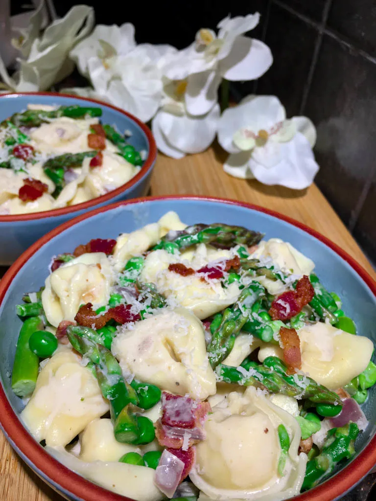 bowls of asparagus bacon and pea tortellini pasta