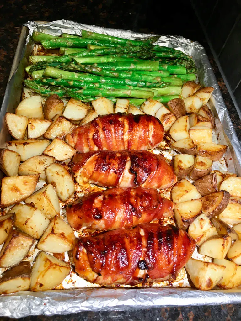 bacon wrapped cheese stuffed bacon plated with asparagus and roasted potatoes