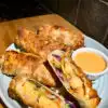 bang bang shrimp egg rolls on a blue plate