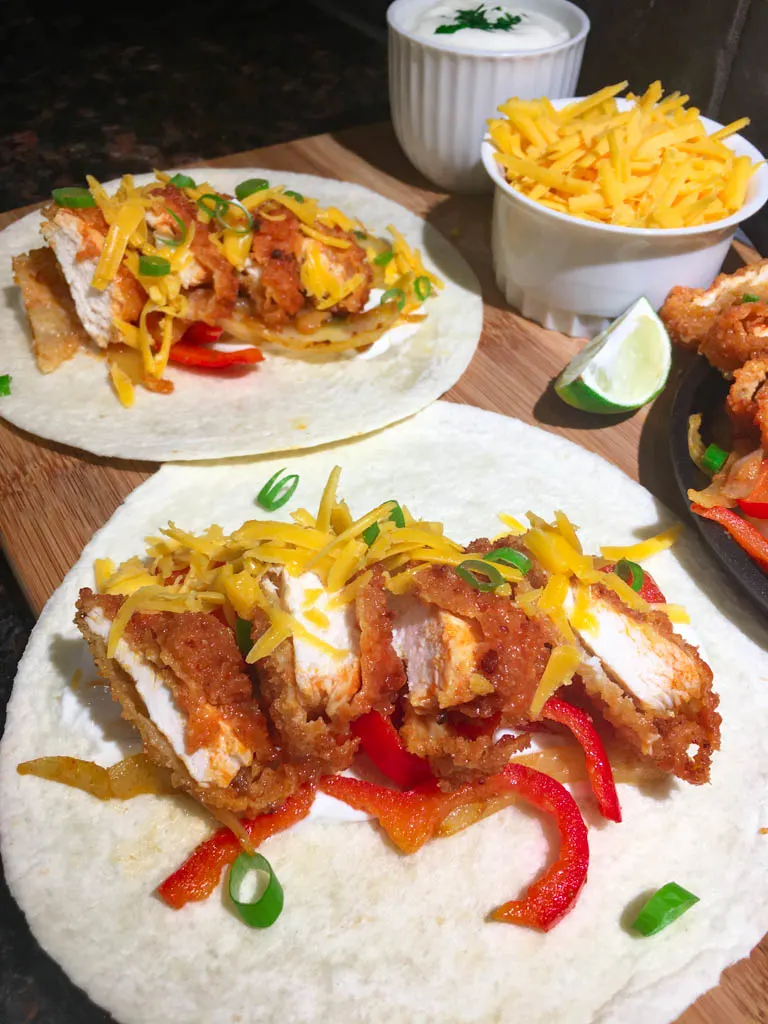 buffalo chicken fajita dinner plated on a wood board