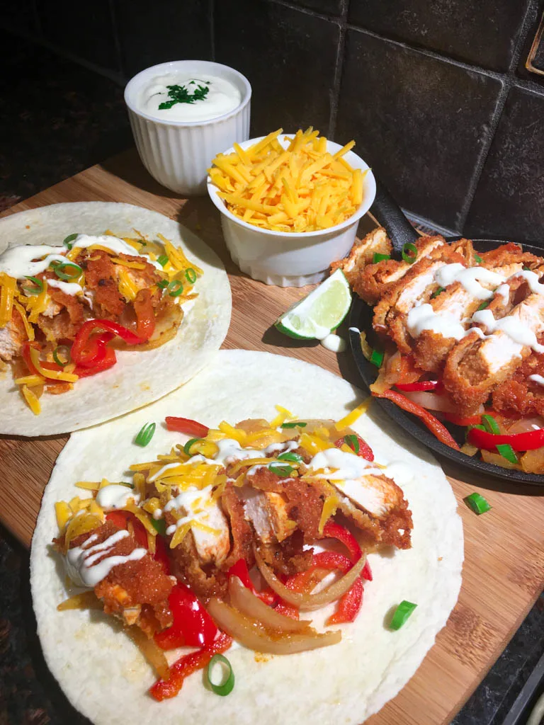 buffalo chicken fajita dinner plated on a wood board