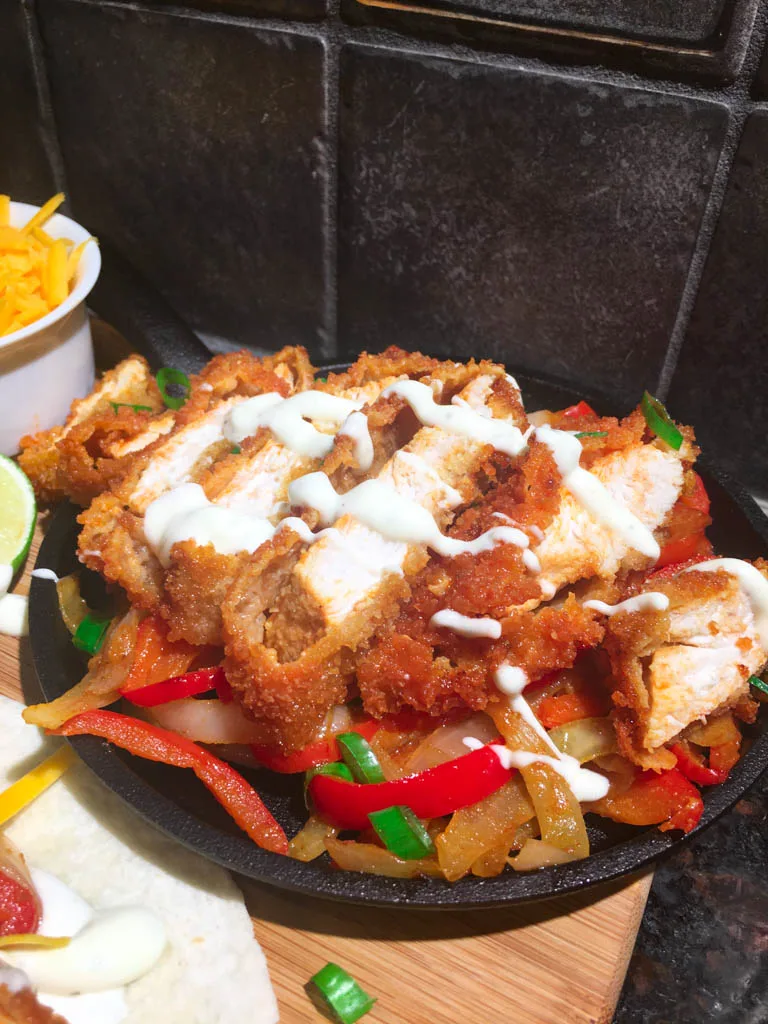 buffalo chicken fajita dinner plated on a wood board