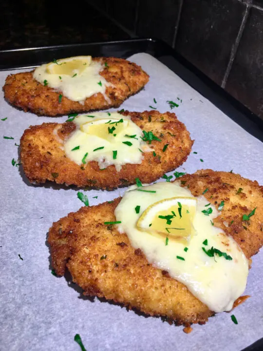 chicken romano cutlets on a cookie sheet