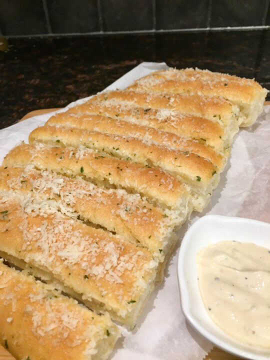 crazy bread on parchment paper and wood board