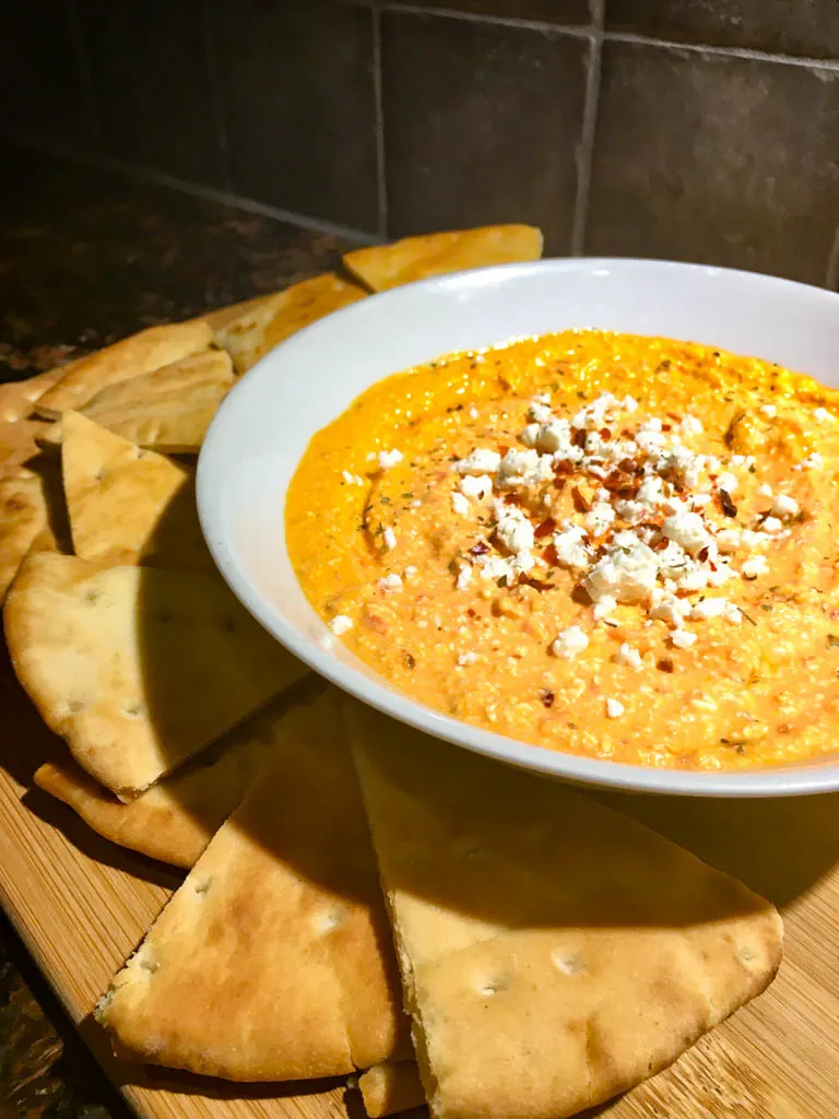 Feta Roasted Red Pepper Dip in a white bowl with pita