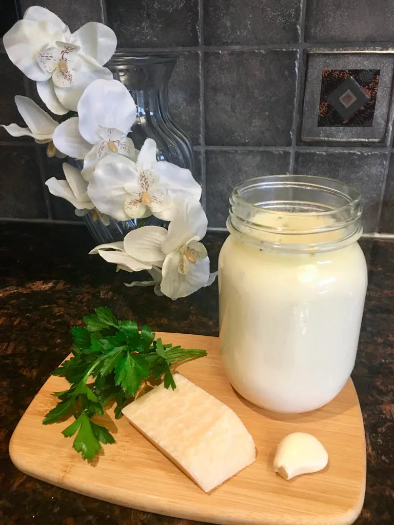 jar of garlic alfredo sauce with parmesan, garlic and parsley