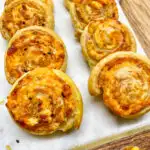 Ham and Cheese Pinwheels on a marble cutting board with wood