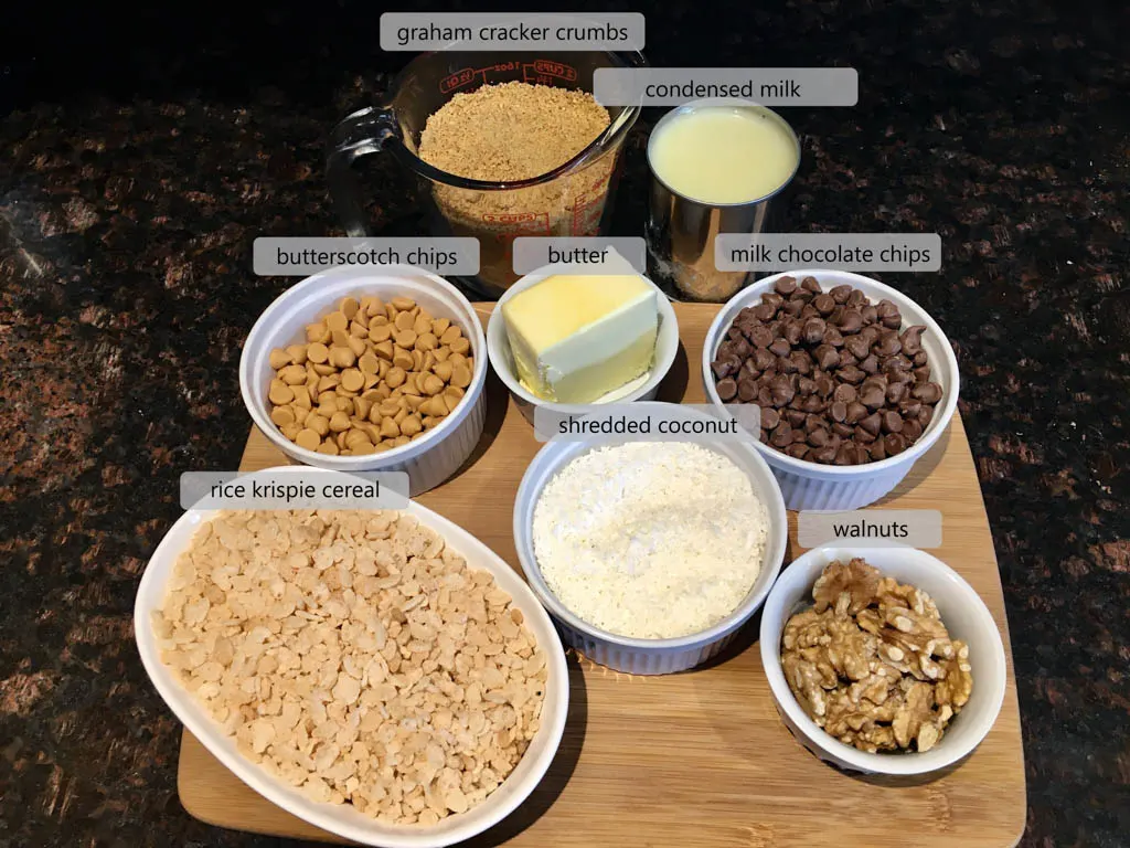 ingredients to make 8 layer magic bars on a wood board