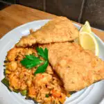 Portuguese Fried Fish Fillets on a blue plate with seafood rice