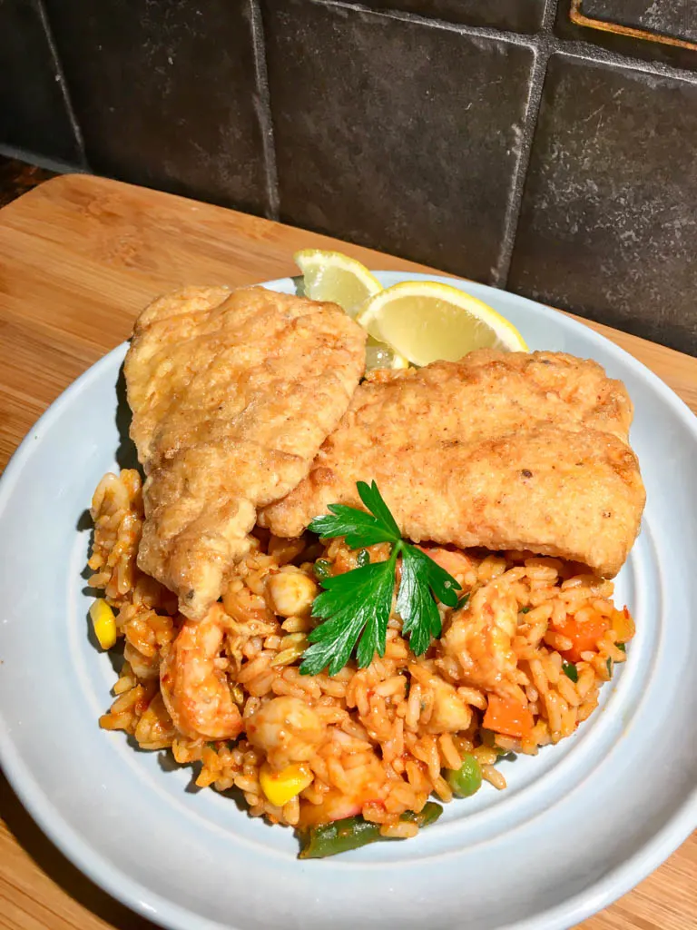 Portuguese Fried Fish Fillets on a blue plate with seafood rice