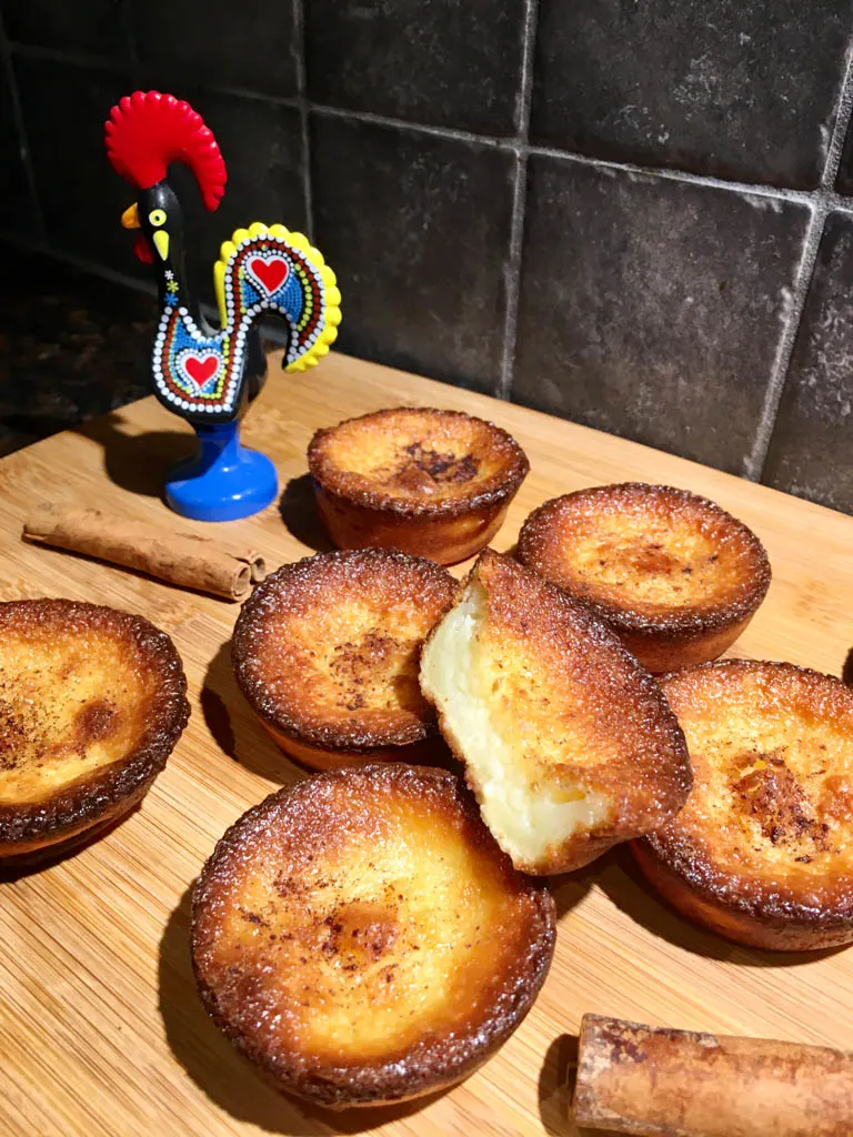 Queijadas de Leite Portugese Tarts plated on a wood board with a rooster