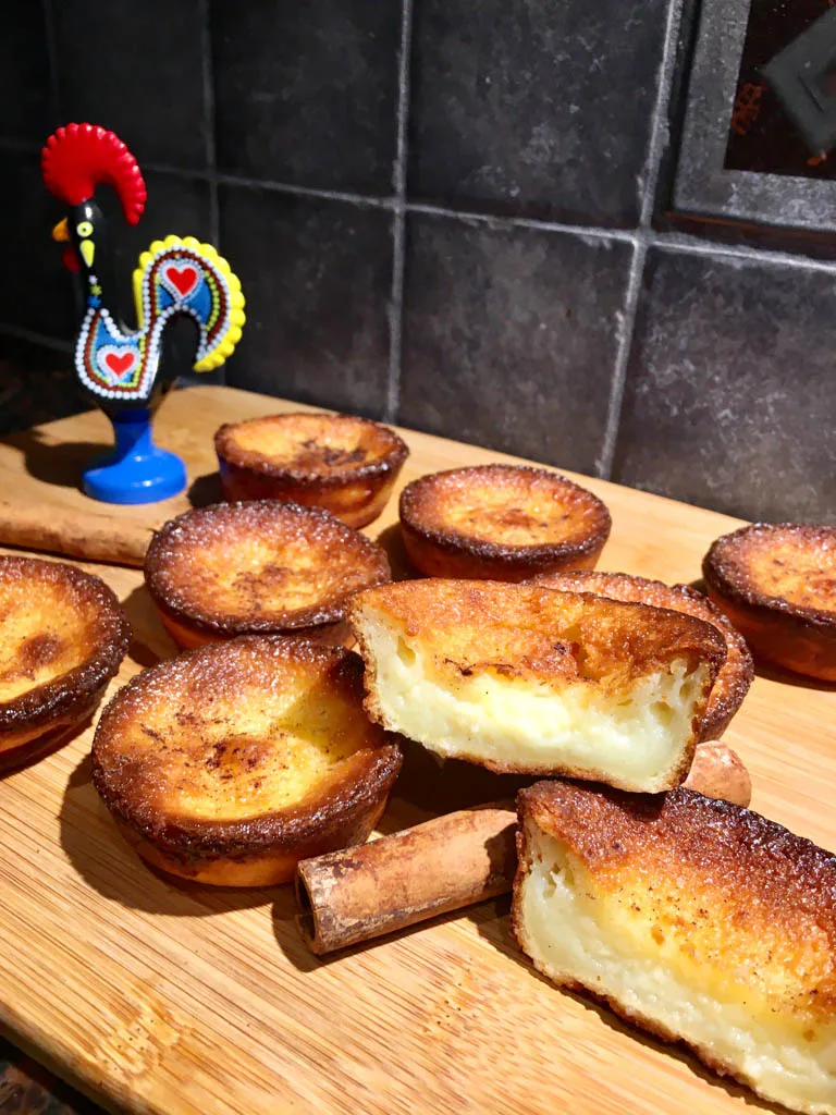 Queijadas de Leite Portugese Tarts plated on a wood board with a rooster