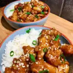 spicy crispy chicken in bowls with rice on a wood board