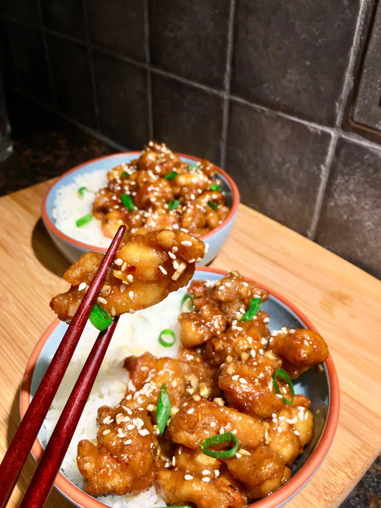 spicy crispy chicken in bowls with rice on a wood board