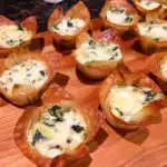 Spinach Artichoke Dip Wonton Cups on a wood board