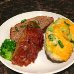 sticky glazed meatloaf plated with a broccoli cheddar twice baked potato