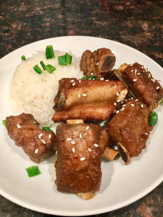 sticky short ribs plated with rice on a white plate