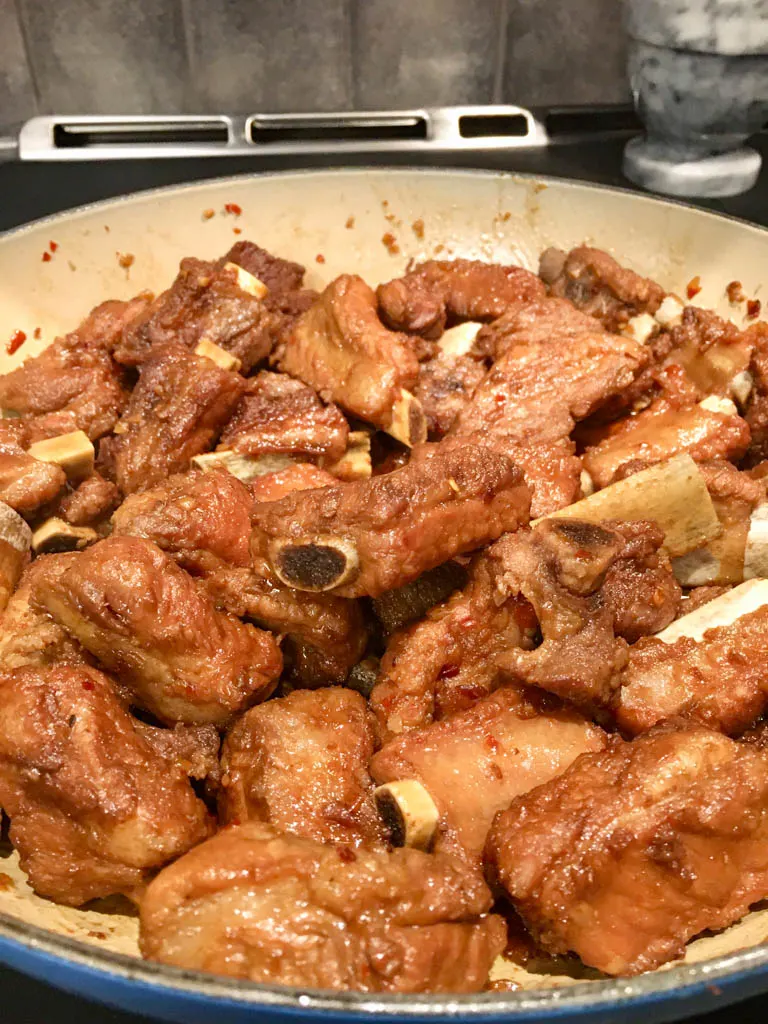 sticky short ribs in a blue skillet