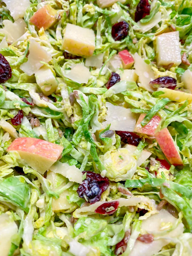 close up of shaved brussels sprout salad with apples and craisins