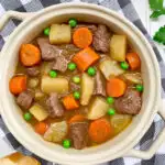 beef stew in a beige bowl with bread