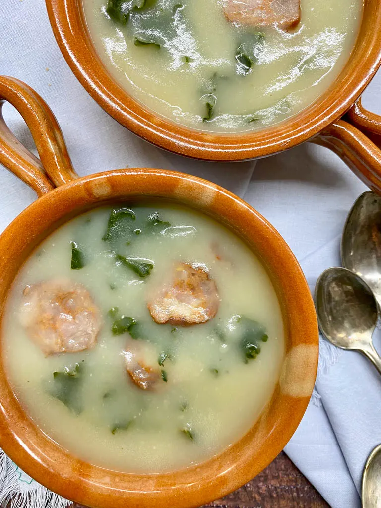 two bowls of caldo verde portuguese kale soup 2 brown bowls