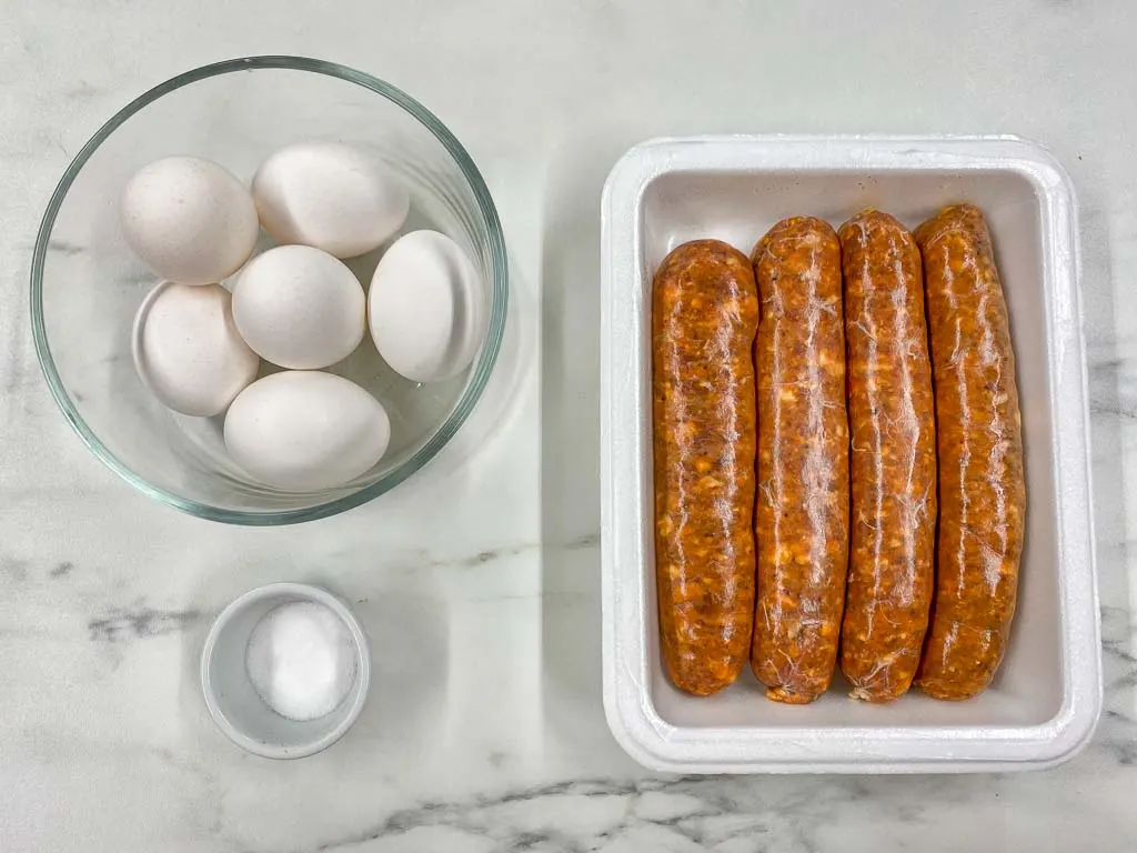 ingredients to make huevos con chorizo in bowls. eggs, chorizo sausage, salt