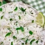 white bowl with cilantro lime rice chipotle copycat recipe and a green checkerboard towel