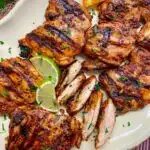 chipotle pollo asado copycat recipe on a white platter with lime and orange wedges