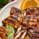 chipotle pollo asado copycat recipe on a white platter with lime and orange wedges