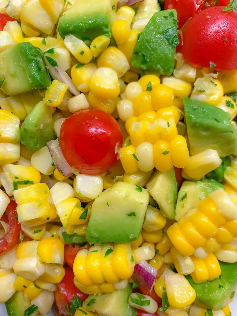 close up image of avocado corn tomato salad