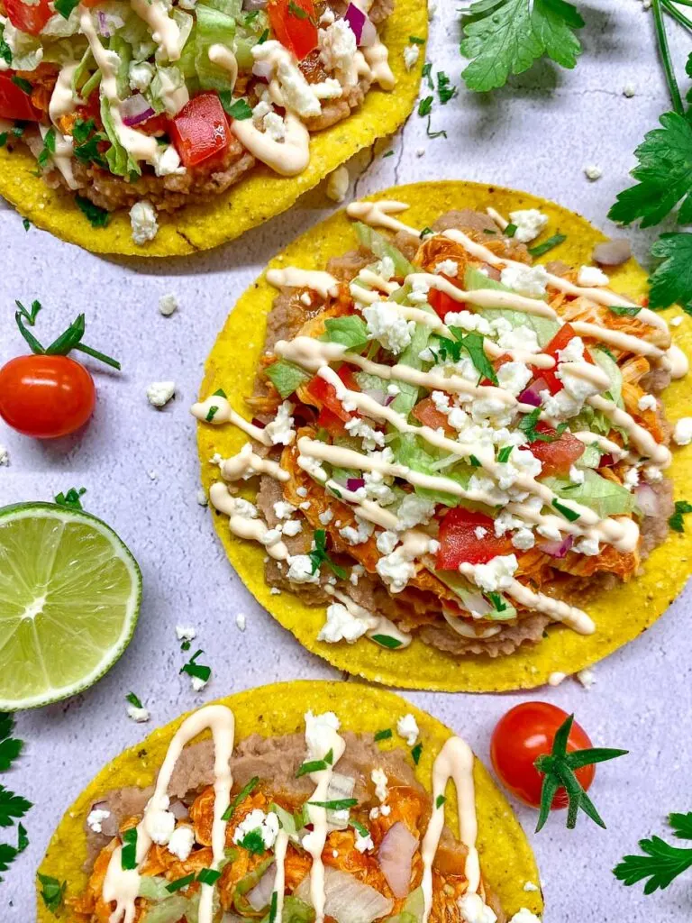 chicken tinga tostadas garnished with cotija cheese and cilantro