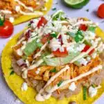 chicken tinga tostadas garnished with cotija cheese and cilantro