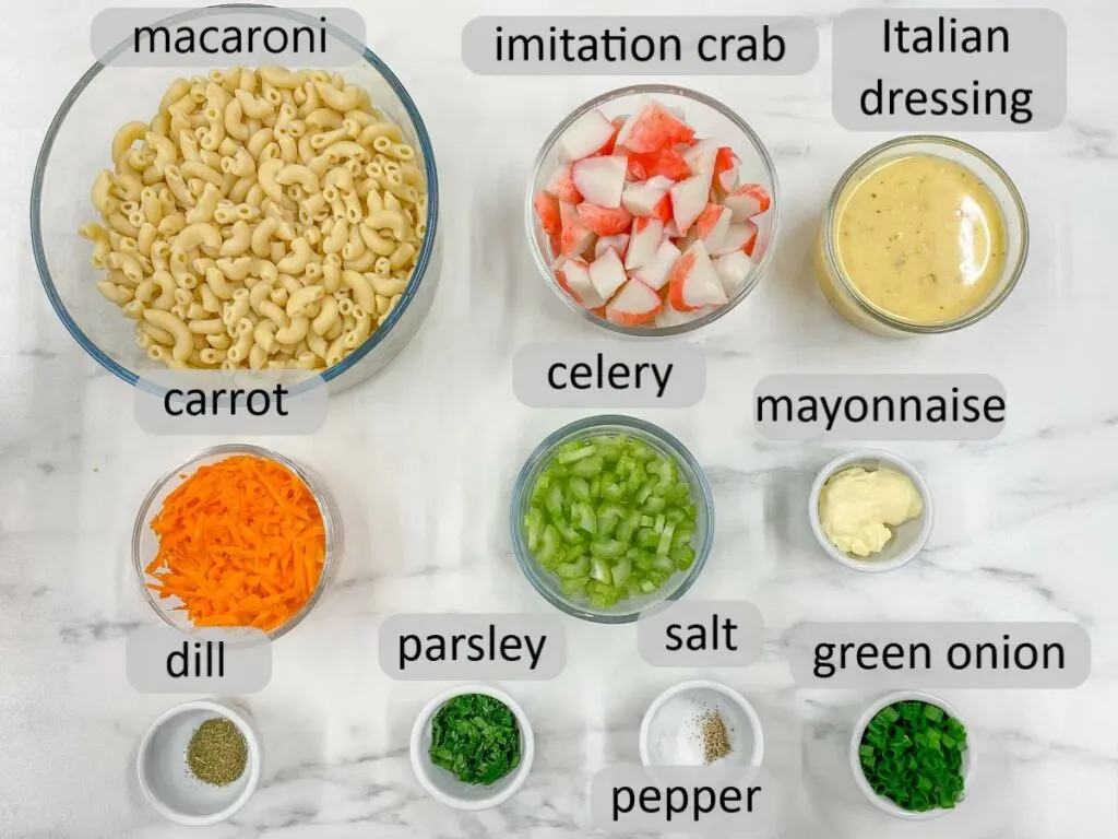 bowls with macaroni, imitation crab, Italian dressing, carrot, celery, mayonnaise, dill, parsley, salt, pepper and green onion. the ingredients to make seafood pasta salad