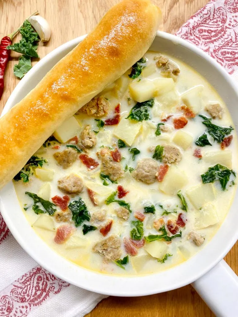 Copycat Olive Garden zuppa toscana recipe in a white bowl with a breadstick