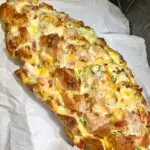 jalapeno popper pull apart garlic bread in a wood board with parchment paper