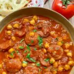 chorizo chickpea stew in a brown bowl garnished with parsley