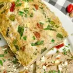 Mediterranean turkey meatloaf on a white plate with feta and parsley