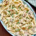 chicken alfredo bake in a blue baking dish garnished with parsley