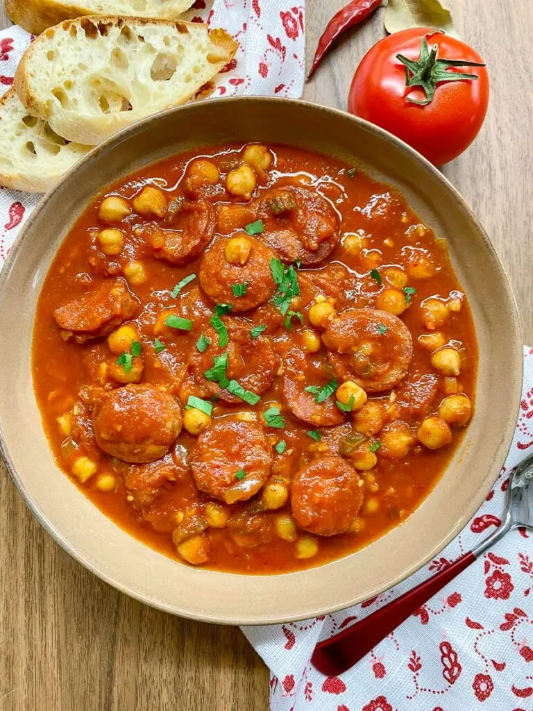 chorizo chickpea stew in a brown bowl garnished with parsley