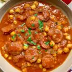 chorizo chickpea stew in a brown bowl garnished with parsley