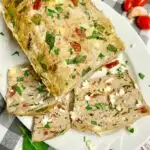 Mediterranean turkey meatloaf on a white plate with feta and parsley