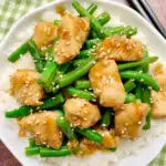 bowl of honey garlic chicken and green beans with rice and sesame seeds