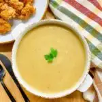 copycat KFC gravy in a white bowl with a side of popcorn chicken