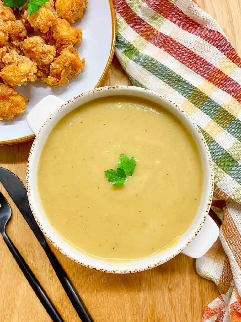 copycat KFC gravy in a white bowl with a side of popcorn chicken