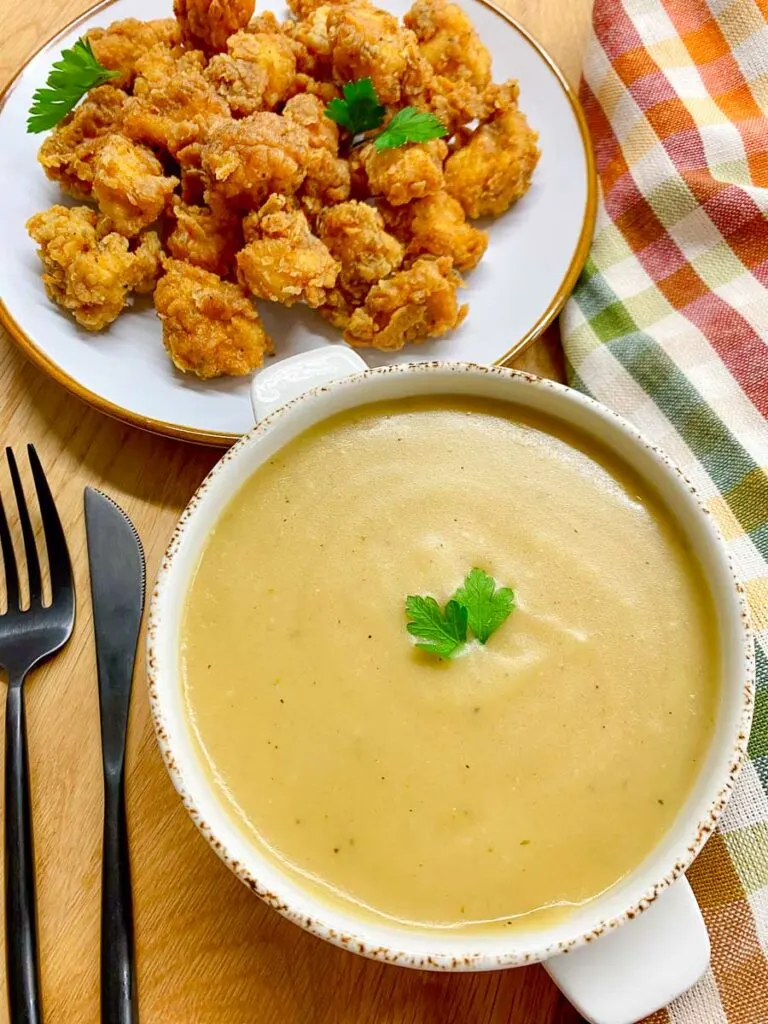 copycat KFC gravy in a white bowl with a side of popcorn chicken