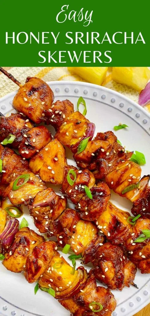 honey sriracha pineapple chicken skewers on a white plate garnished with green onions